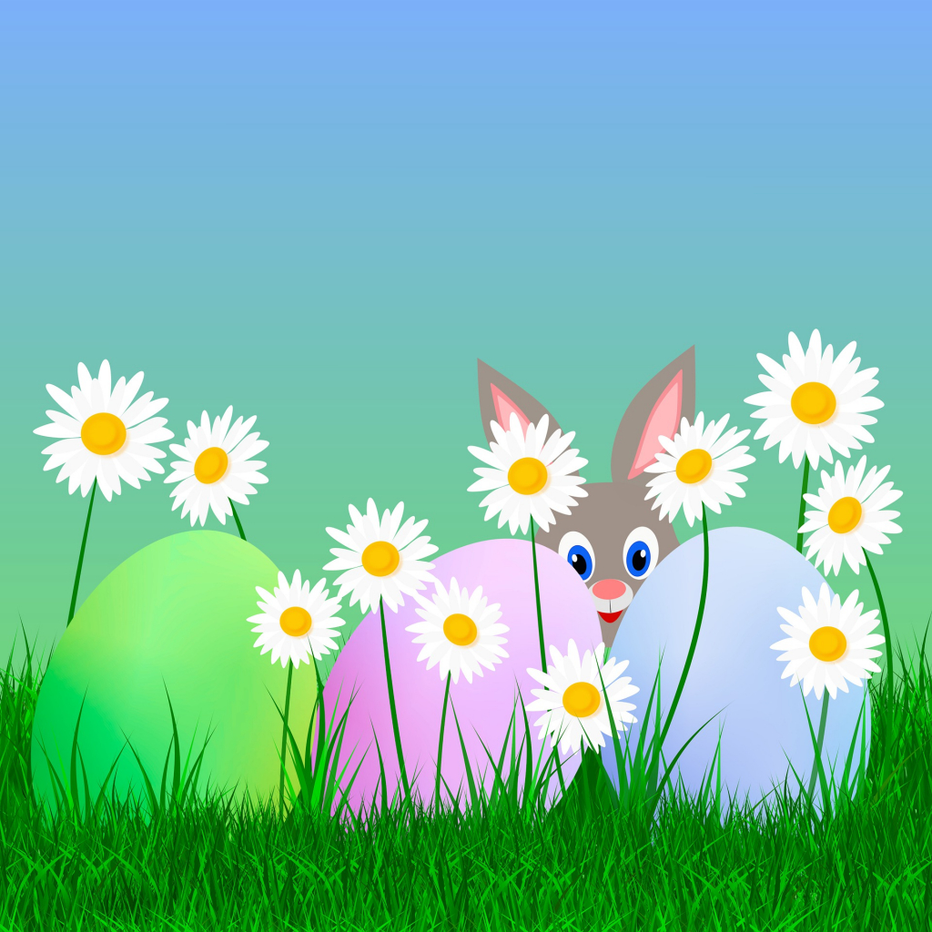 Osterhase auf Wiese mit bunten Eiern