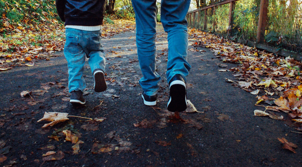 Spaziergang Vater und Sohn auf Herbstweg